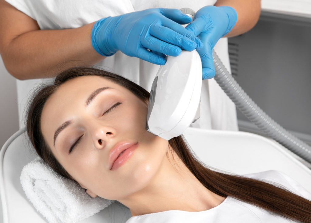 Elos epilation hair removal procedure on the face of a woman. Beautician doing laser rejuvenation in a beauty salon. Facial skin care. Hardware ipl cosmetology | Thrive Wellness in Cummings Hwy, Chattanooga, TN